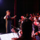 Music teacher conducting student orchestra at Qingdao International School during a live performance, highlighting the arts and music education at Qingdao Amerasia International School.